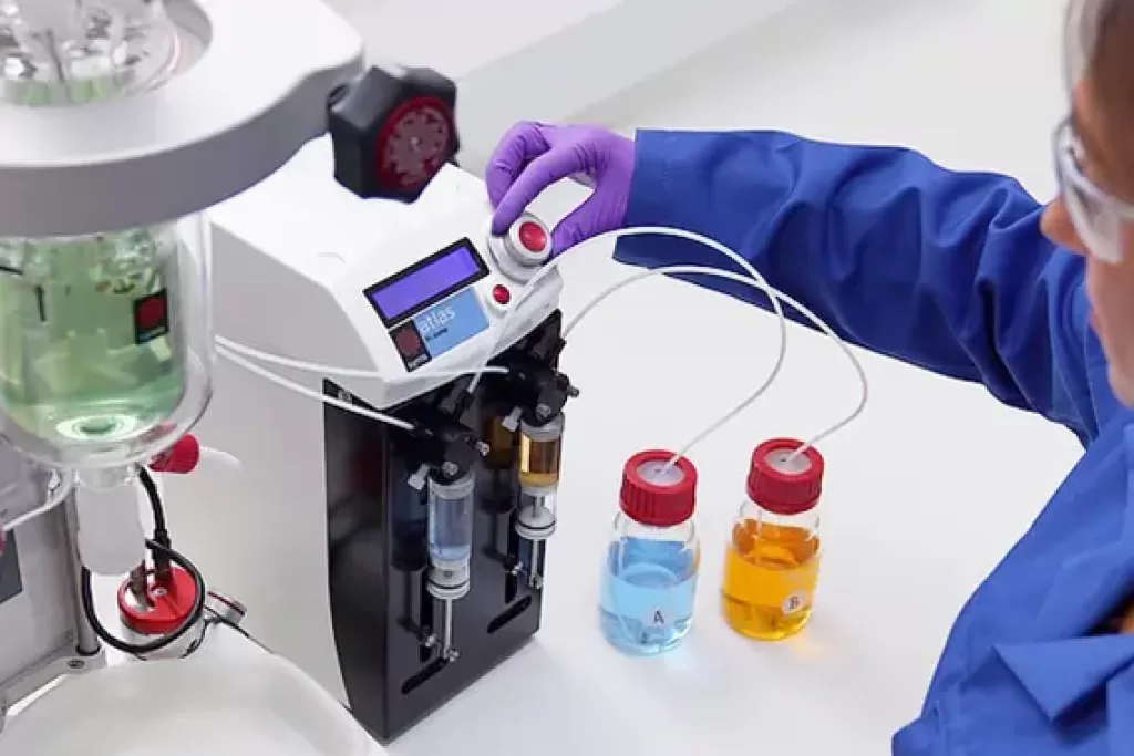 A chemist using the Atlas Syringe Pump in the lab