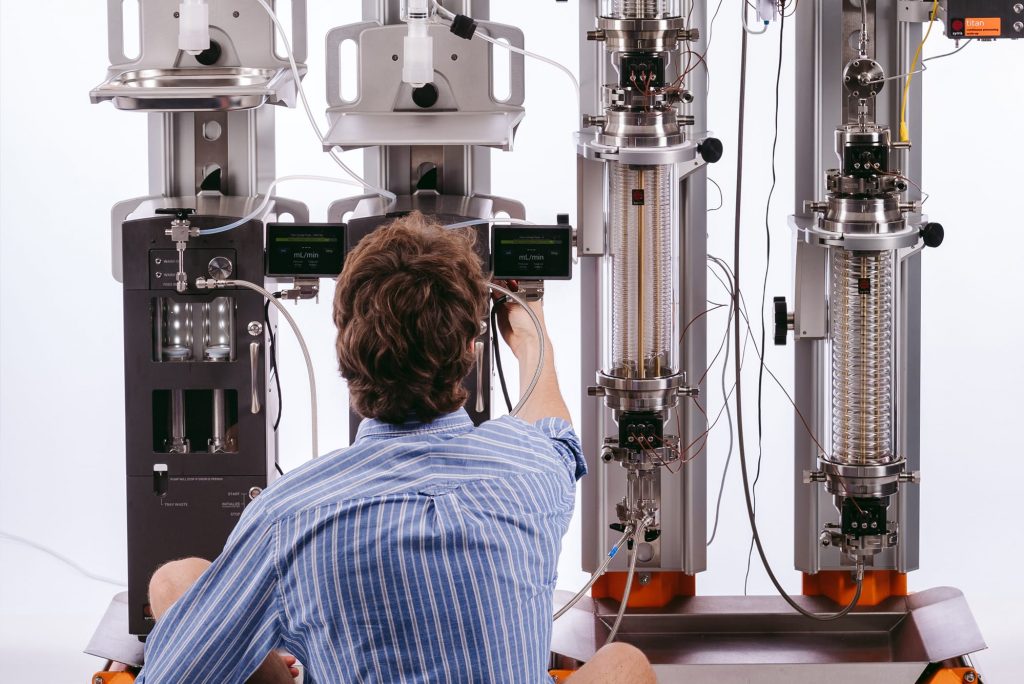 A chemist setting up Syrris Titan flow chemistry scale up system for use